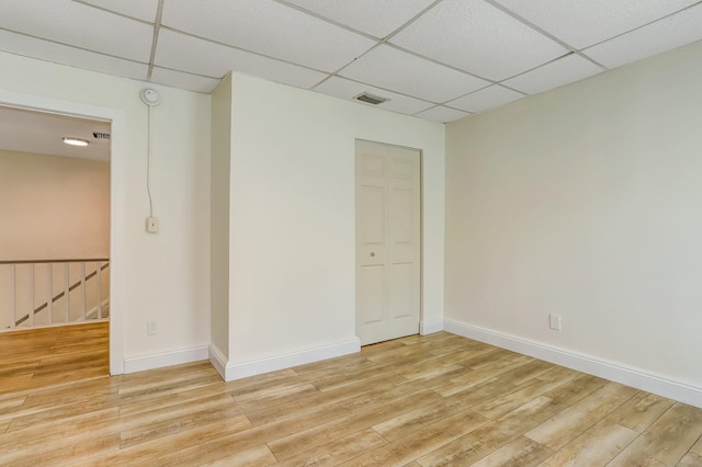 unfurnished room featuring a paneled ceiling and light wood-type flooring