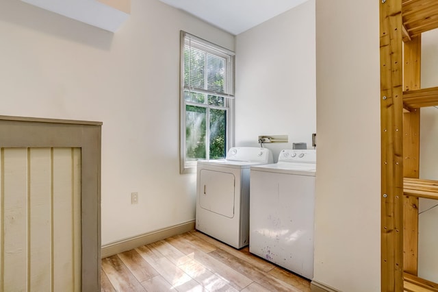 washroom with light hardwood / wood-style flooring and washer and dryer