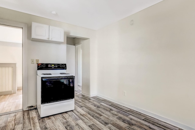 kitchen featuring electric range oven, white cabinets, and light wood-type flooring