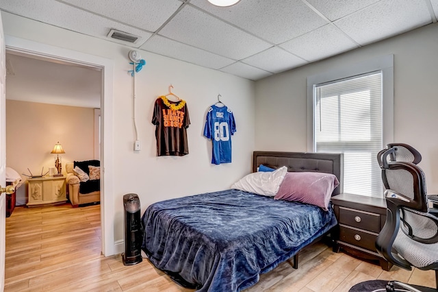 bedroom with hardwood / wood-style flooring and a drop ceiling