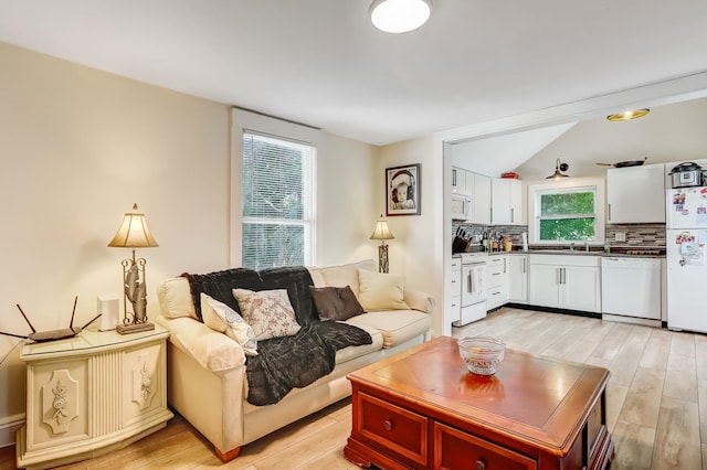 living room featuring lofted ceiling and light wood-type flooring