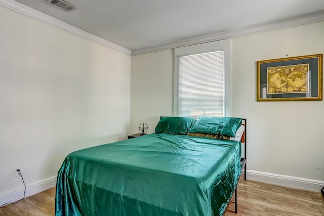 bedroom featuring crown molding and hardwood / wood-style flooring