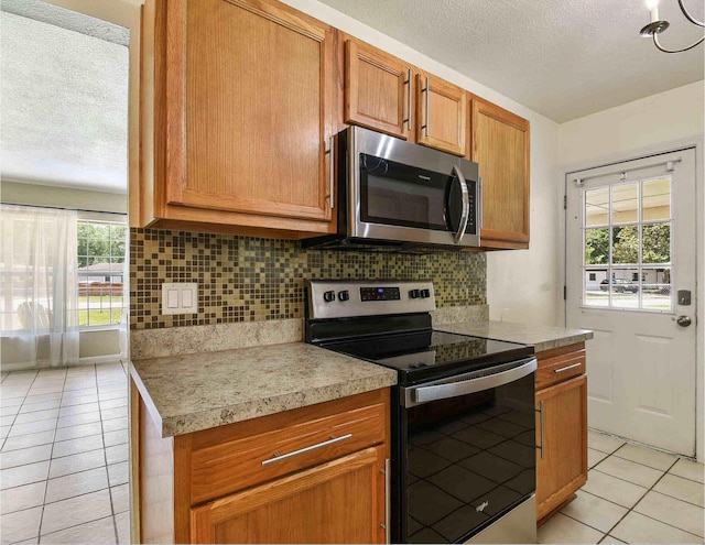 kitchen with decorative backsplash, a textured ceiling, and appliances with stainless steel finishes