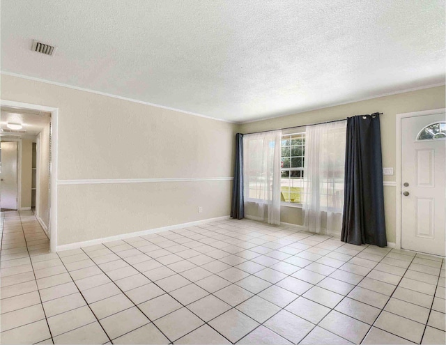 unfurnished room with crown molding, light tile patterned floors, and a textured ceiling