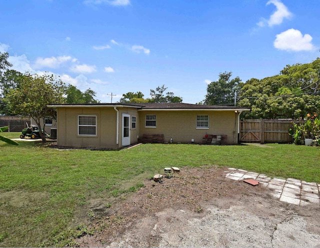 rear view of property featuring a lawn