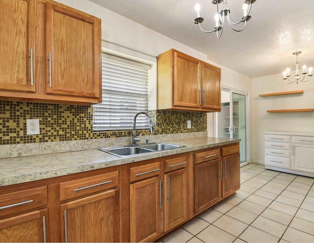 kitchen with backsplash, sink, light tile patterned floors, decorative light fixtures, and a chandelier