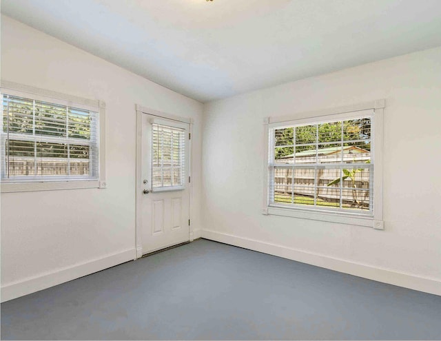 empty room featuring concrete floors and plenty of natural light