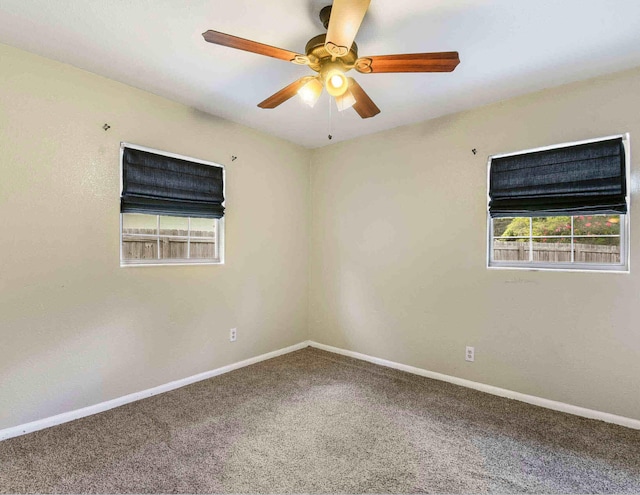 carpeted spare room featuring ceiling fan