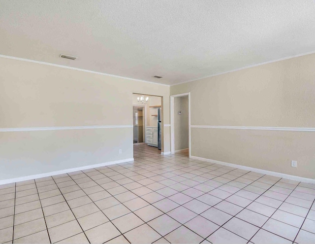 spare room with crown molding, light tile patterned floors, a chandelier, and a textured ceiling