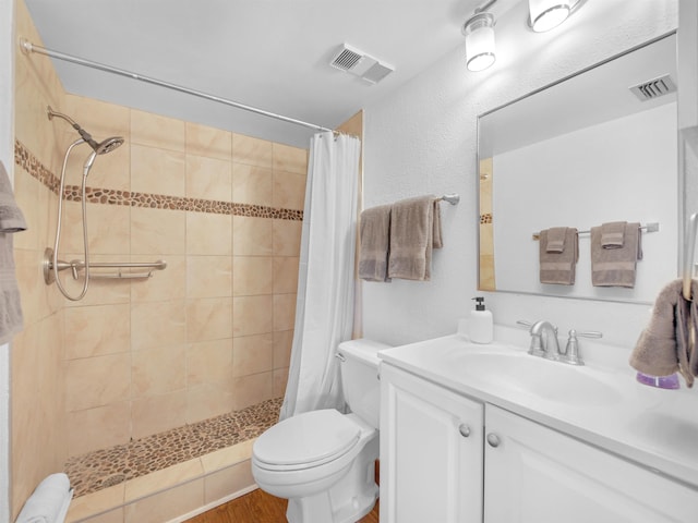4250 S A1A Unit D33, Saint Augustine, FL 32080 - bathroom with a tile shower, toilet, vanity, wood finished floors, and a textured wall