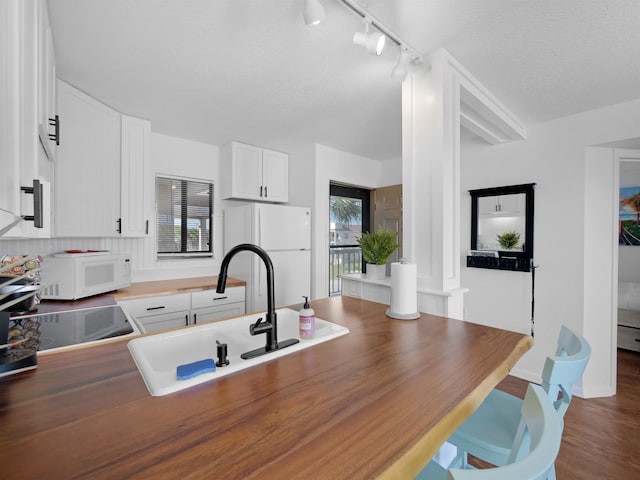 4250 S A1A Unit D33, Saint Augustine, FL 32080 - kitchen with white appliances, a sink, butcher block counters, white cabinets, and track lighting