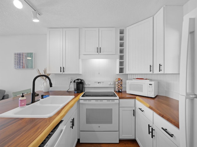 4250 S A1A Unit D33, Saint Augustine, FL 32080 - kitchen with butcher block counters, white appliances, a sink, a textured ceiling, and white cabinetry