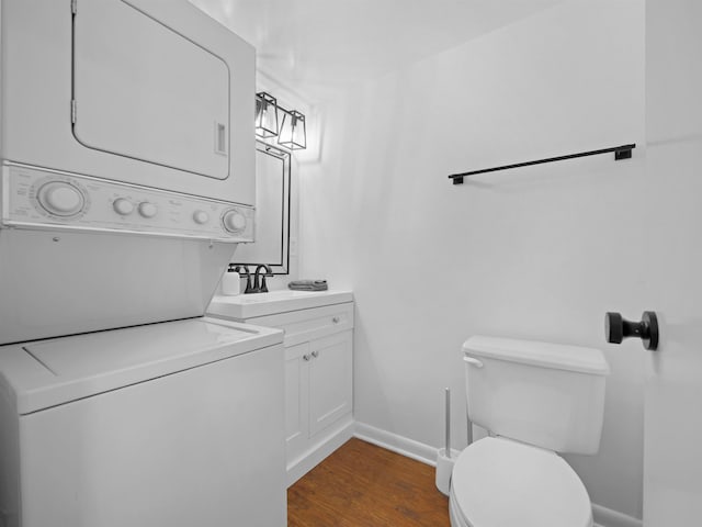 4250 S A1A Unit D33, Saint Augustine, FL 32080 - bathroom with estacked washer and dryer, toilet, baseboards, wood finished floors, and vanity