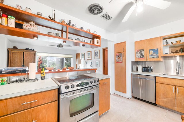 kitchen with light tile patterned floors, stainless steel appliances, ceiling fan, and sink