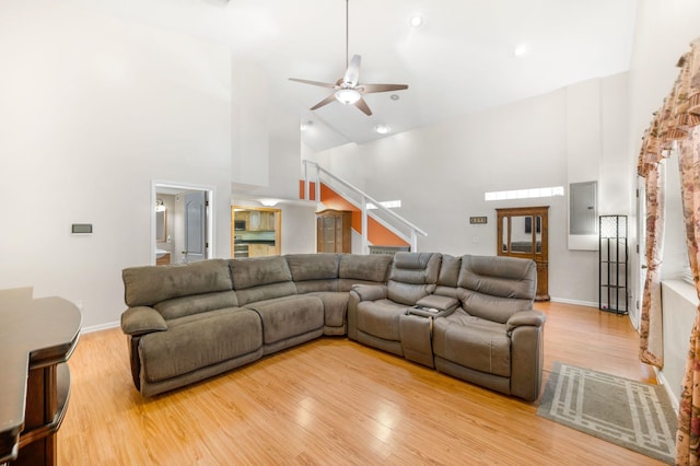 living room featuring ceiling fan, light hardwood / wood-style floors, and high vaulted ceiling