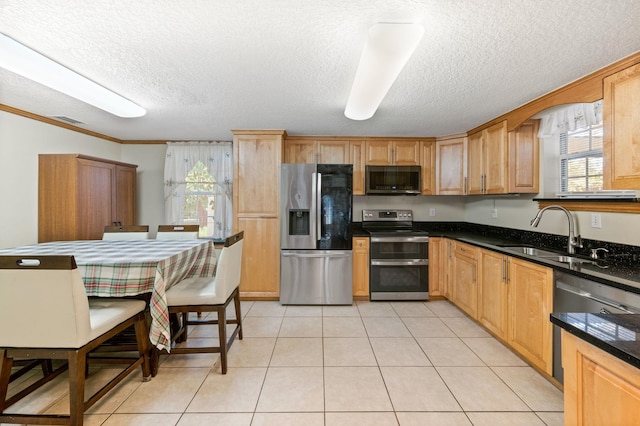 kitchen with sink, crown molding, appliances with stainless steel finishes, a textured ceiling, and light tile patterned flooring