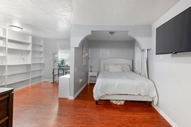 bedroom featuring hardwood / wood-style floors and a textured ceiling