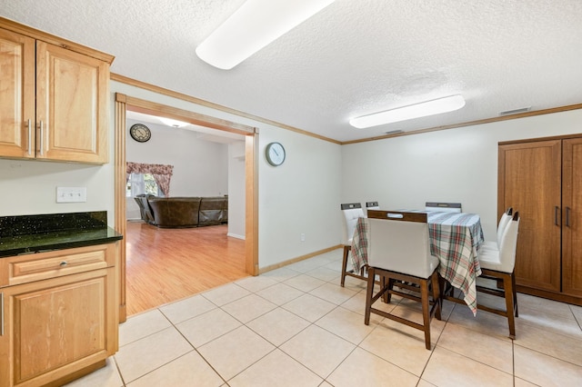 dining space featuring crown molding, a textured ceiling, and light tile patterned floors