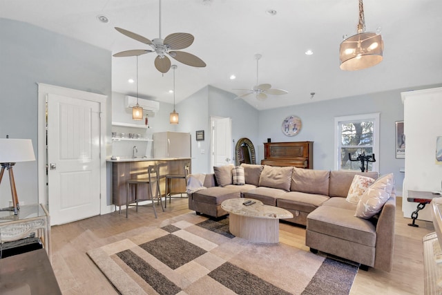 living room featuring light wood-type flooring, ceiling fan, lofted ceiling, and sink