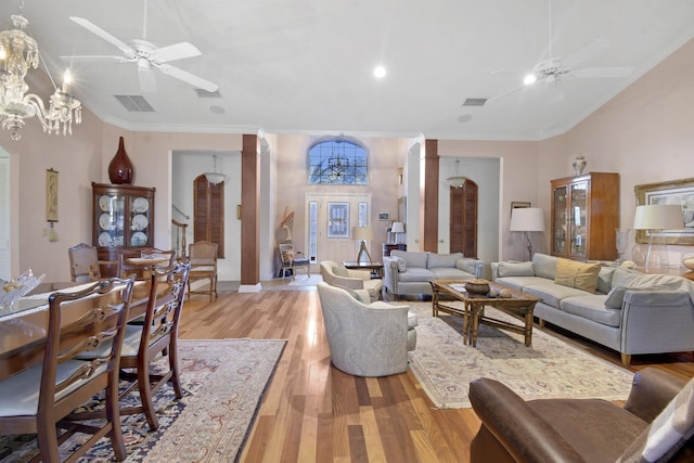 living room with light hardwood / wood-style flooring, ceiling fan with notable chandelier, and ornamental molding