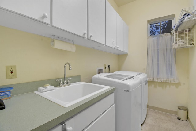 laundry room with cabinets, light tile patterned floors, sink, and washing machine and clothes dryer