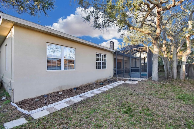 view of home's exterior with glass enclosure