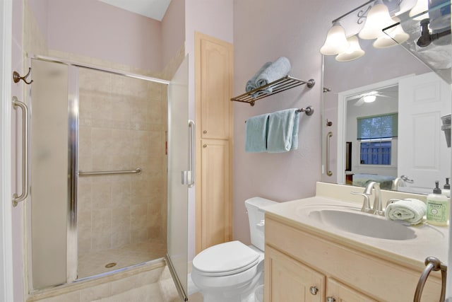 bathroom featuring ceiling fan, vanity, an enclosed shower, and toilet