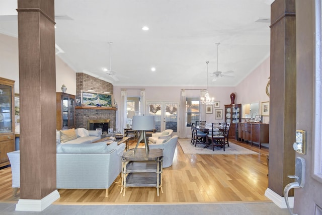 living room featuring wood-type flooring, ornamental molding, and decorative columns