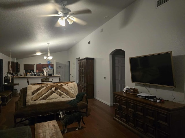 living area featuring wood finished floors, ceiling fan with notable chandelier, arched walkways, lofted ceiling, and visible vents