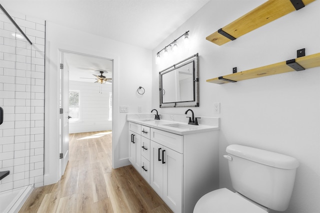 full bathroom featuring a shower, wood finished floors, a sink, and toilet