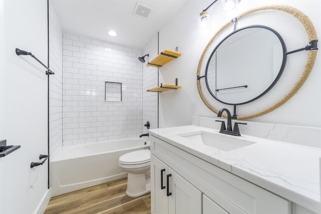 full bath featuring visible vents, toilet, vanity, wood finished floors, and shower / bathtub combination