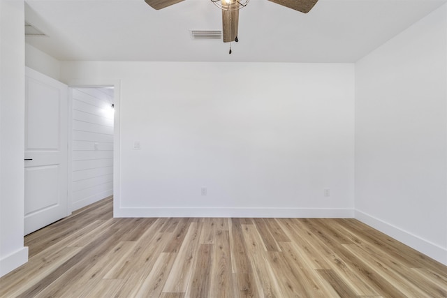 empty room featuring baseboards, a ceiling fan, visible vents, and light wood-style floors