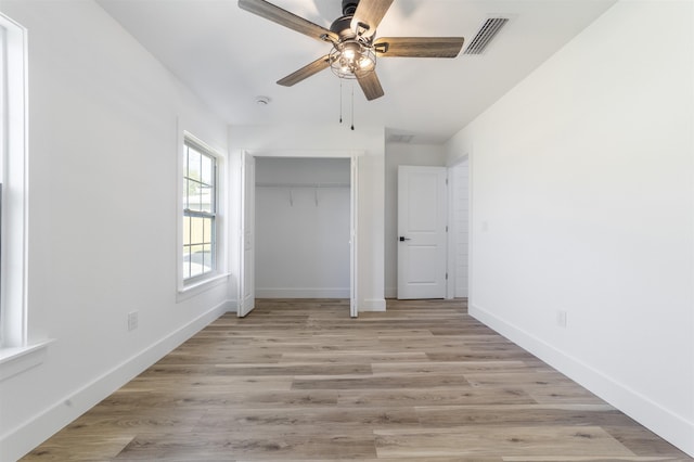 unfurnished bedroom with light wood finished floors, baseboards, visible vents, and a closet