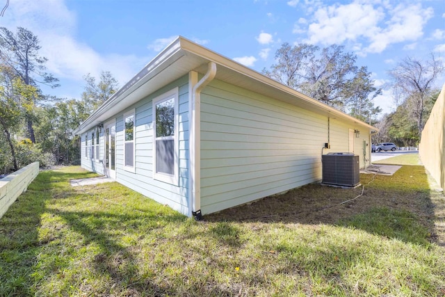 view of property exterior with a lawn and cooling unit