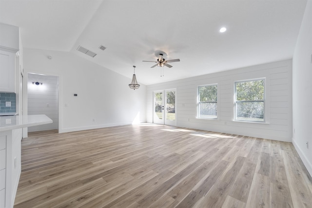 unfurnished living room featuring light wood-style floors, visible vents, vaulted ceiling, and a ceiling fan