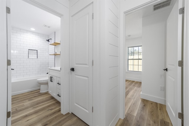 bathroom with baseboards, visible vents, and wood finished floors