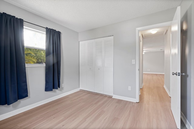 82 Andora St, Saint Augustine, FL 32086 - unfurnished bedroom with baseboards, a closet, a textured ceiling, attic access, and wood finished floors