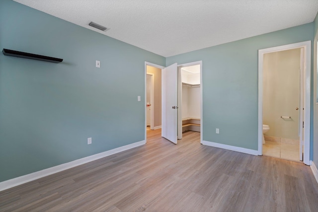 82 Andora St, Saint Augustine, FL 32086 - unfurnished bedroom with baseboards, a closet, a spacious closet, visible vents, and wood finished floors