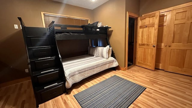 bedroom with light hardwood / wood-style floors and a closet