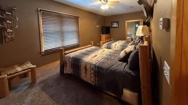 bedroom with ceiling fan and dark colored carpet