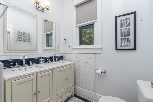 60 Saragossa St, Saint Augustine, FL 32084 - bathroom featuring toilet, double vanity, tile walls, and a sink
