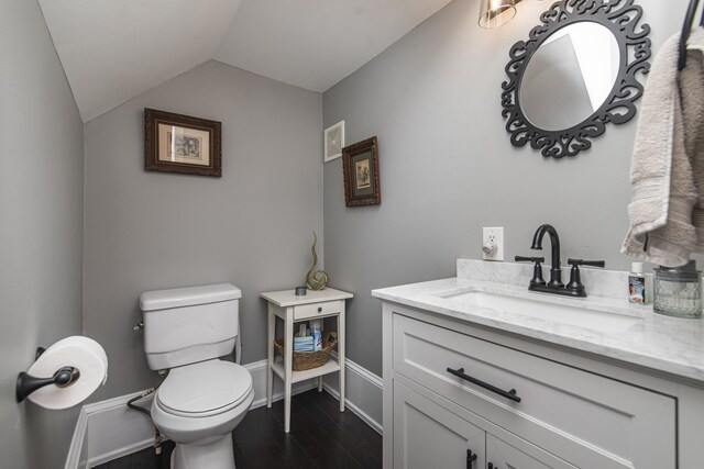 60 Saragossa St, Saint Augustine, FL 32084 - half bath with toilet, vaulted ceiling, vanity, wood finished floors, and baseboards