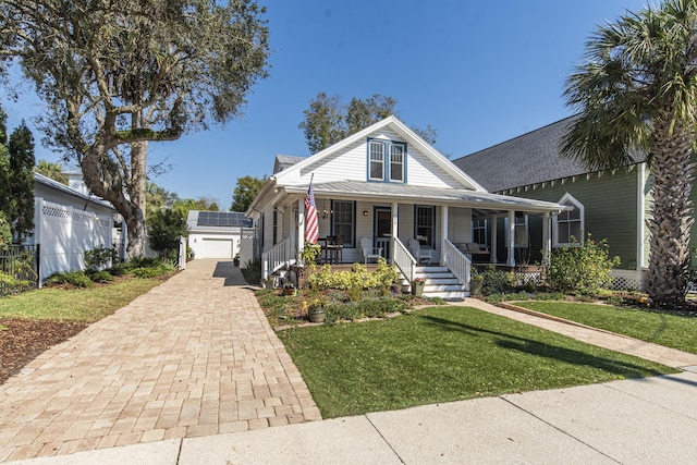 bungalow-style house with covered porch, decorative driveway, and a front yard