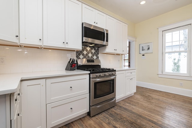 60 Saragossa St, Saint Augustine, FL 32084 - kitchen with tasteful backsplash, baseboards, dark wood finished floors, stainless steel appliances, and white cabinetry