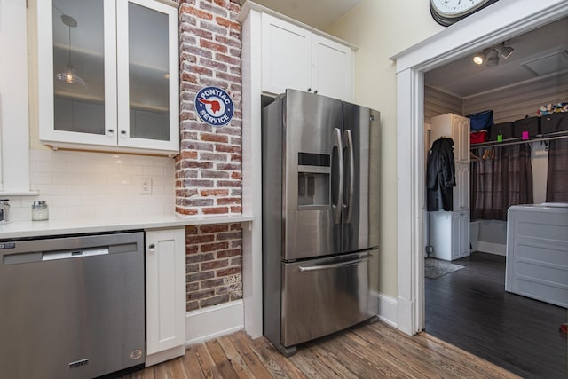 60 Saragossa St, Saint Augustine, FL 32084 - kitchen with stainless steel appliances, wood finished floors, white cabinets, light countertops, and washer / clothes dryer