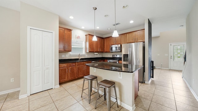 191 Timberwood Dr, Saint Augustine, FL 32084 - kitchen featuring a kitchen bar, light tile patterned floors, a kitchen island, a sink, and appliances with stainless steel finishes