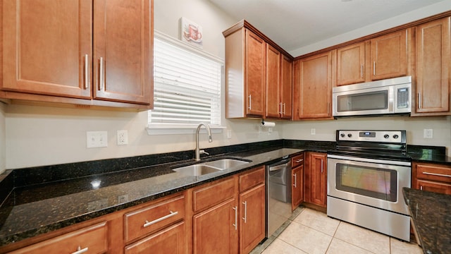 191 Timberwood Dr, Saint Augustine, FL 32084 - kitchen with light tile patterned flooring, dark stone counters, stainless steel appliances, a sink, and brown cabinetry