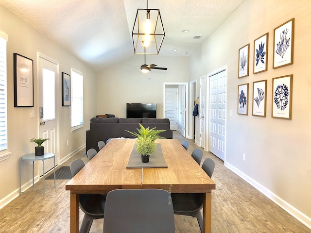 3877 Laurel St, Saint Augustine, FL 32084 - dining room with wood finished floors, baseboards, ceiling fan, vaulted ceiling, and a textured ceiling