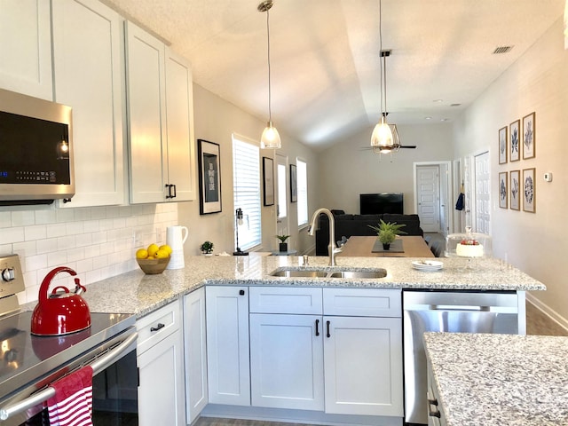 3877 Laurel St, Saint Augustine, FL 32084 - kitchen with appliances with stainless steel finishes, a sink, a peninsula, lofted ceiling, and open floor plan