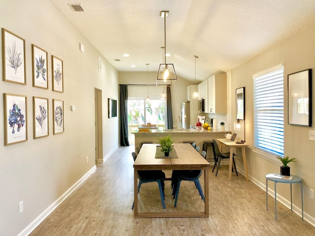 3877 Laurel St, Saint Augustine, FL 32084 - dining space with light wood-style floors, baseboards, and lofted ceiling